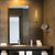 Elegant bathroom interior featuring a sleek, modern mirror illuminated by a stylish wall light fixture, enhancing the ambiance with warm, soft lighting.