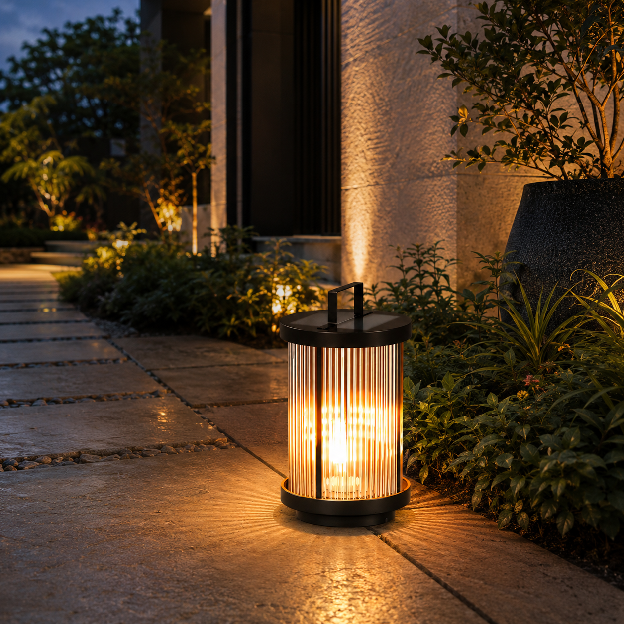 EMILY solar garden path light glowing warm white beside plants along a modern outdoor walkway